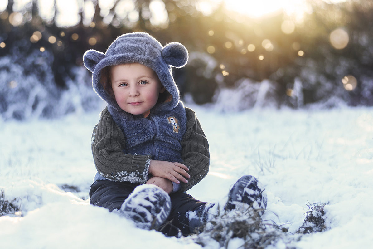 Kamila Svobodová fotografka – dětský portrét. Chlapec sedí na sněhu.